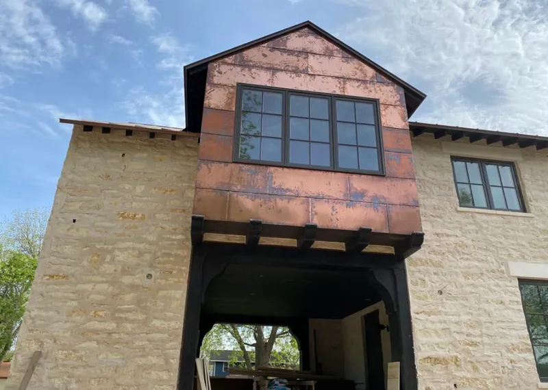 Copper metal panel facade on a stone building for Roof Repair in Bozeman