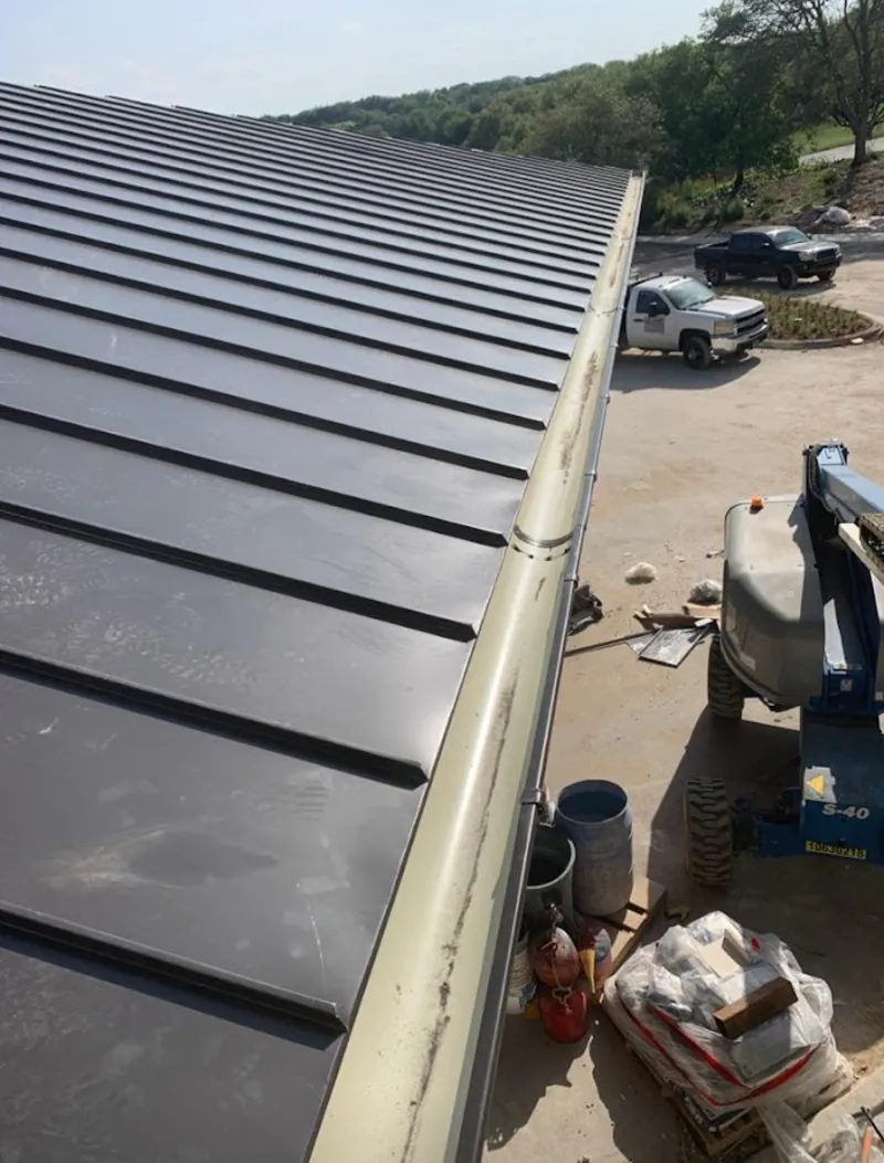 Standing seam panel and gutter detail on a metal roofing jobsite in Bozeman